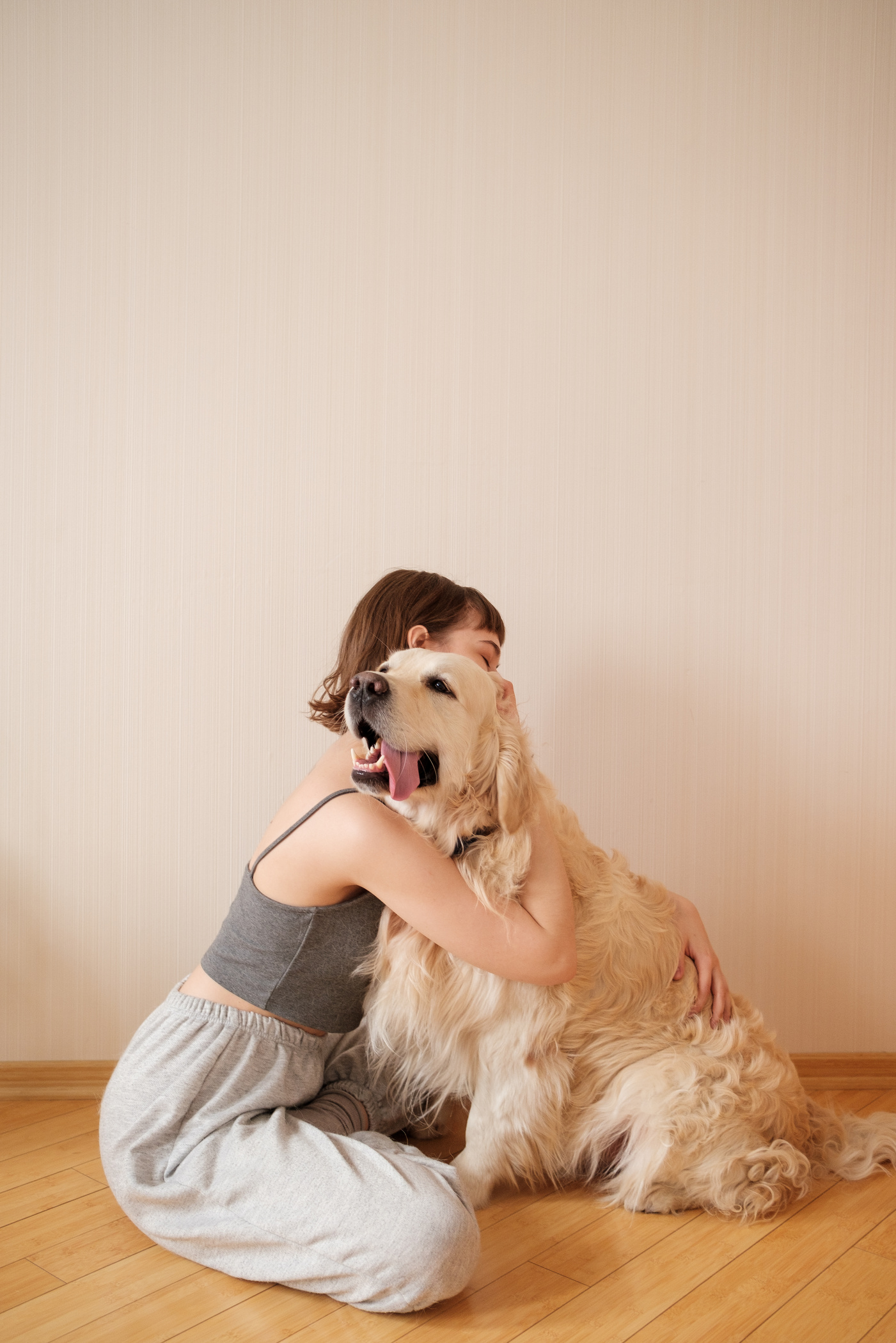 Young Woman Hugging Pet Dog on the Floor